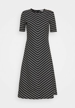 Robe noire à manches courtes avec des rayures horizontales blanches en motif chevron, un col rond et une fermeture éclair sur le côté.