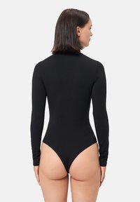 Body de manga larga negro hecho de tela elástica con cuello alto y diseño de tanga en la parte trasera, textura suave y forma ajustada.