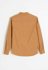 Brązowa koszula z długimi rękawami i kołnierzykiem zapinanym na guziki. Posiada gładką fakturę, mankiety zapinane na jeden guzik oraz zaokrąglony dół.