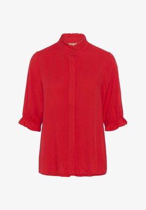 Blusa roja con un alto cuello con volantes, cierre de botones sutil y mangas cortas con detalles fruncidos. Tejido suave sin patrones.