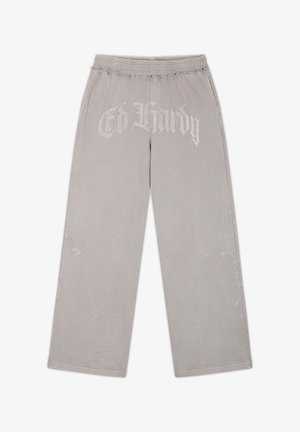 Vaaleanharmaat leveälahkeiset housut, joissa joustava vyötärö, edessä "Ed Hardy" -logo ja sivuilla hillityt kirjailut kukkakuosilla.