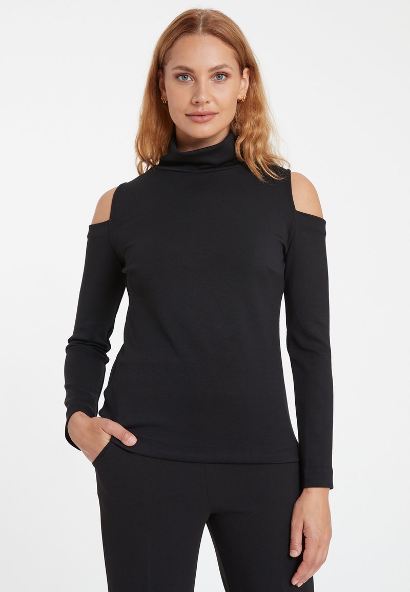 Schwarzes Langarmoberteil mit hohem Kragen und Cold-Shoulder-Design, aus weichem Material gefertigt, mit körperbetonter Silhouette und seitlichen Taschen.