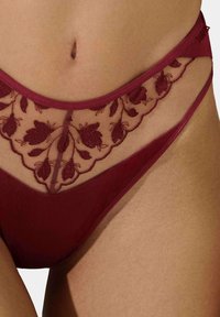 Bordeaux lingerie met bloemendessin op gaas, met een strakke, lichaamssluitend pasvorm en decoratieve geschulpte randen.