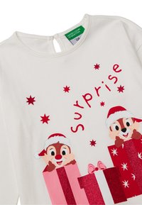Weißes Langarmshirt mit Cartoon-Streifenhörnchen in roten und pinken Geschenkboxen, rotem Schriftzug "Überraschung" und glitzernden Sternakzenten.