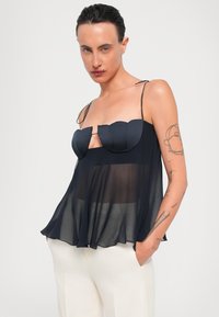 Top negro transparente con un corsé estructurado que presenta copas con bordes de pico, tirantes finos y un dobladillo fluido. Diseño sencillo sin elementos metálicos visibles.