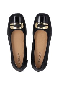 Ballerine nere realizzate in materiale morbido, con punta lucida nera e dettagli in hardware dorato, e una soletta beige testurizzata.