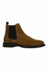 Bruine suède Chelsea-boot met zwarte elastische zijpanelen, ronde neus en een lage zwarte hak. Groene lus aan de achterkant voor gemakkelijk aan- en uittrekken.