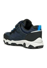 Scarpa sportiva blu navy con cavigliera imbottita, fascia in Velcro e suola bianca a contrasto. Presenta dettagli neri testurizzati e una linguetta blu.