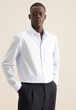 Camicia a righe blu chiaro con bottoni, realizzata in misto cotone, caratterizzata da maniche lunghe, taschino sul petto e colletto classico, abbinata a pantaloni scuri.