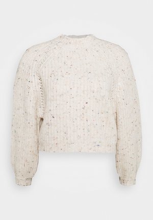 Maglione crema corto e spesso con lavorazione a maglia testurizzata, caratterizzato da piccole macchie colorate, polsini a costine e collo alto.