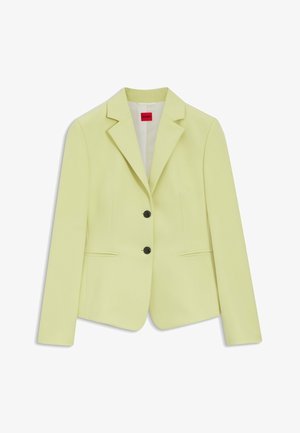 Jasnozielona damska marynarka z klapami z wycięciem, dwoma czarnymi guzikami i dwoma przednimi kieszeniami z rozcięciami, z metką HUGO wszytą wewnątrz kołnierzyka.