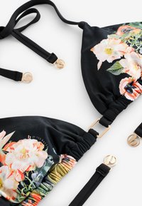 Top de bikini floral negru cu accesorii aurii. Prezintă un imprimeu floral în roz și alb, bretele ajustabile și șnururi pentru formă.