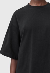 Sort oversized t-shirt lavet af bomuld. Har en rund halsudskæring og korte ærmer med en blød tekstur. Enkel og minimal design.