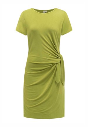 Lys grønn kjole med korte ermer, rund hals og en samlet knutedetalj på høyre side som skaper myke, draperte folder.