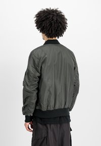 Zaļš bumbērjakas ar spīdīgu apdari, ribota apkakle un piedurknes, elastīgs jostasvieta un sānu kabatas. Strukturēta auduma ar saplacinātu detalizāciju.