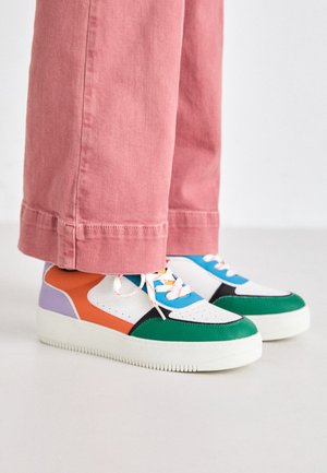 Barevné tenisky s akcenty v zelené, oranžové, fialové a modré barvě, s bílým základem, texturovanými panely a robustní bílou podrážkou.