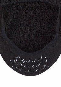 Svart strumpa med en texturerad insida och ett mönstrat gummigrepp på sulan för ökad greppförmåga. Slät finish på övre kanten.
