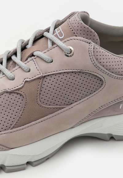 Light gray sneakers with a mix of suede and perforated accents. Features flat gray laces and a textured white midsole. Subtle branding detail.