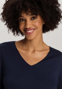 Haut bleu marine en V, en tissu doux, à manches courtes, design ajusté, texture lisse, couture complémentaire le long du décolleté.
