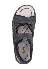 Sandales noires avec sangles Velcro ajustables, semelle intérieure texturée, design ouvert à l'avant et accents marron. Présente des détails cousus et un logo.