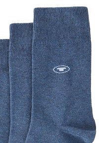 Calcetines de algodón azul con textura acanalada, de longitud corta, y un pequeño logo blanco cerca del puño. Acabado suave y color uniforme en toda su extensión.