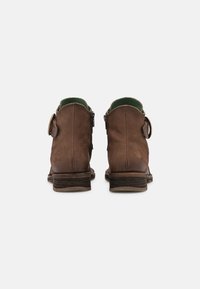 Botas de tornozelo em couro castanho com biqueira arredondada, acabamento texturizado, forro verde, fecho lateral e um pequeno detalhe metálico no salto.
