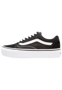 Niskie czarne i białe buty do skateboardingu z białymi sznurowadłami, białym paskiem po boku i grubą białą gumową podeszwą na białym tle.