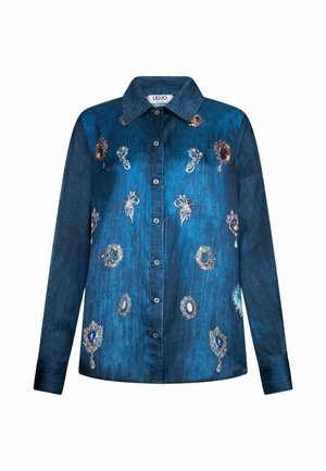 Camicia in denim blu scuro a maniche lunghe con bottoni e colletto, caratterizzata da design di spille ornate sparse e stampe floreali.