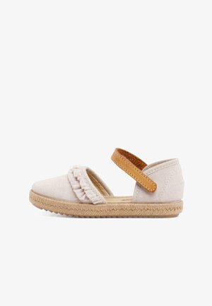 Espadrille beige clair avec un dessus en tissu texturé, des dettagli de volants à l'avant, et une sangle ajustable marron. Semelle en jute tissée.