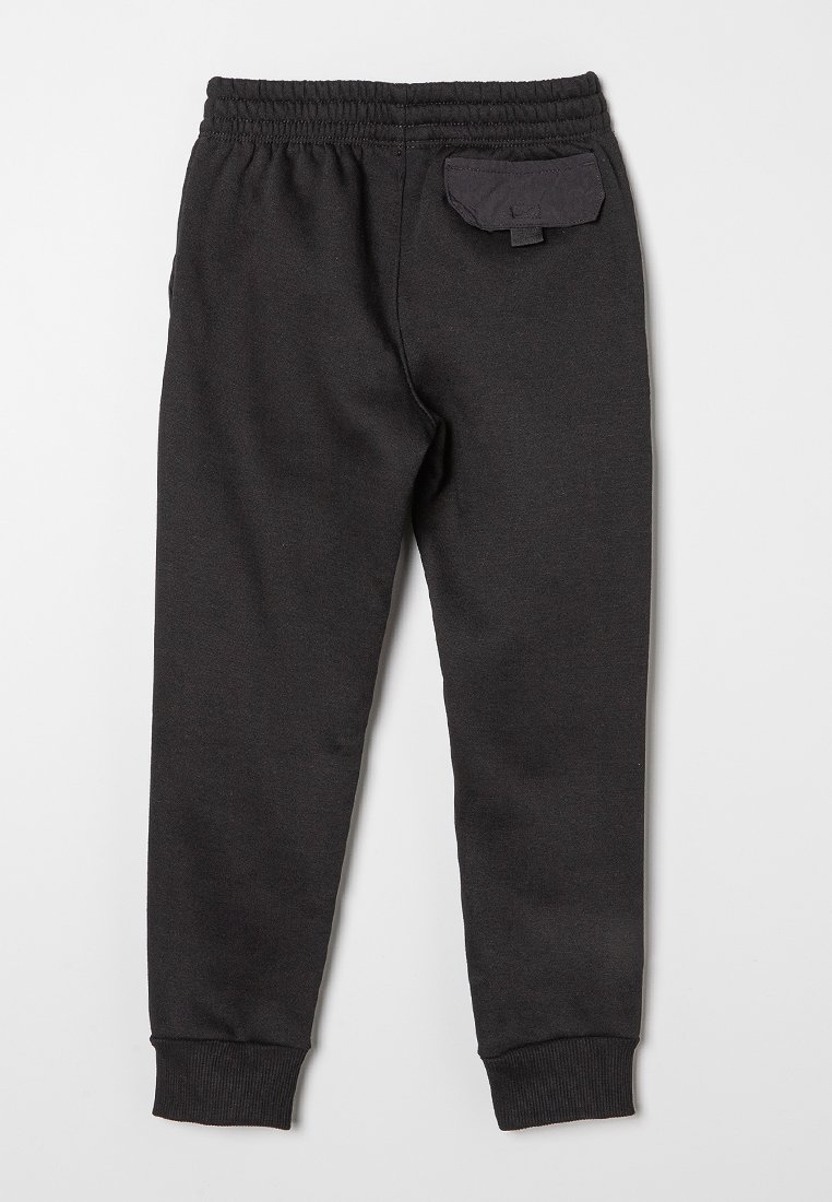 Pantalones de chándal negros con cintura y puños elásticos, que presentan un pequeño bolsillo trasero con tapa. Tejido suave con una textura lisa.