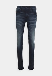 Mörkblå jeans med en urtvättad look, slim fit, fem fickor och metallknapplås. Tillverkade av denimtyg med synliga söm detaljer.