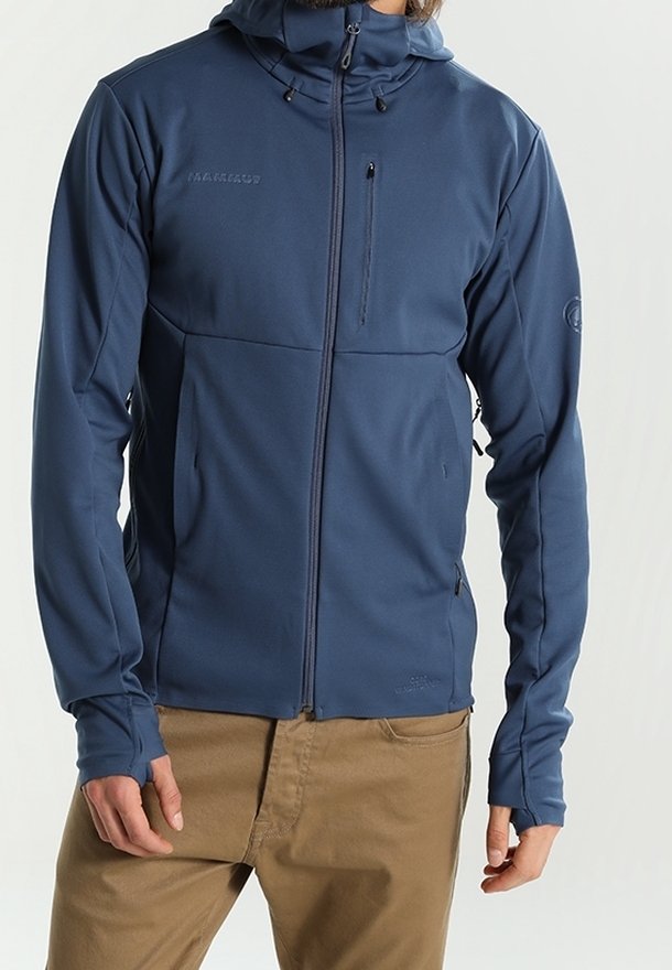Marineblå zip-up jakke lavet af blødt, strækbart stof. Har hætte, lynlåslomme på brystet og tætsiddende ærmer med tommelfingerhuller.