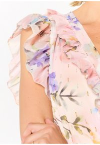 Blommig chiffon topp i rosa och lila nyanser, med volangärmar och guldaccenter. Lätt, genomskinlig textur med intrikata mönster.