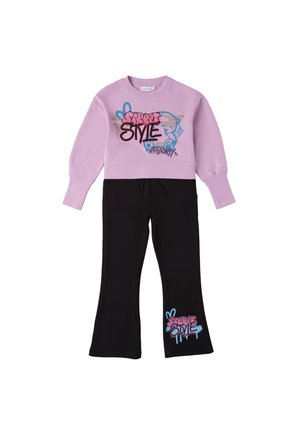 Felpa viola con testo in stile graffiti, abbinata a pantaloni neri a campana con un design grafico simile in rosa e blu.