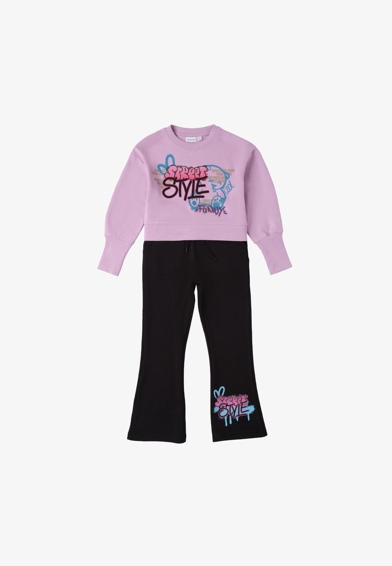 Lila Sweatshirt mit Graffiti-ähnlichem Text, kombiniert mit schwarzen Schlaghosen, die ein ähnliches grafisches Design in Pink und Blau aufweisen.