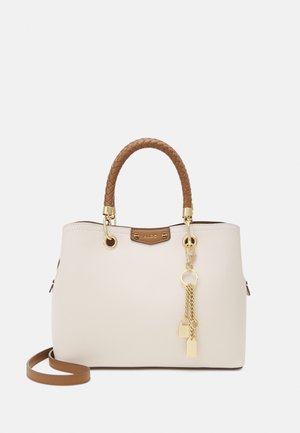 Sac à main beige avec poignée tressée marron, garnitures dorées et breloque décorative dorée suspendue à une poignée.