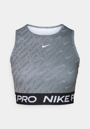 Soutien-gorge de sport Nike Pro court en gris avec une bande élastique noire. Présente des rayures verticales et un motif logo subtil. Texture lisse, design sans manches.
