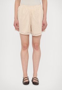 Crème kleurige gehaakte shorts met een elastische taille, met een losse pasvorm en een textuurpatroon, die net boven de knie eindigen.