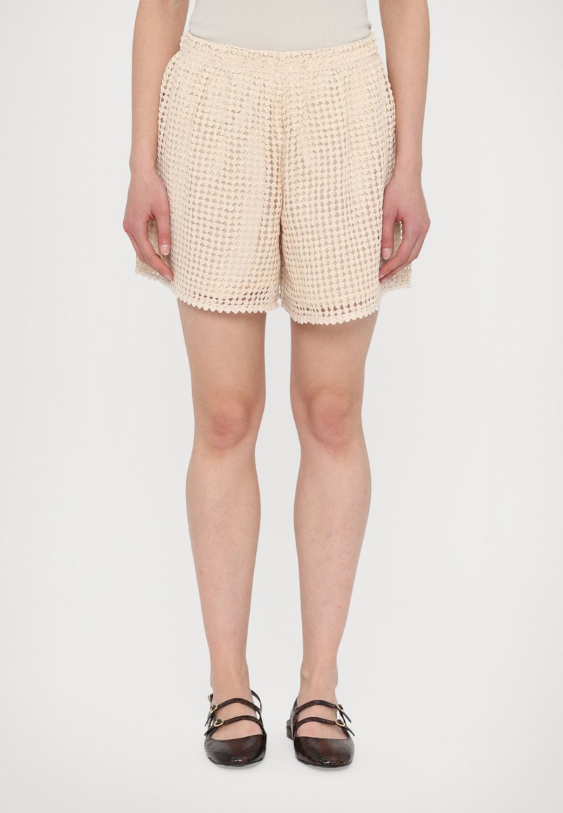 Crème kleurige gehaakte shorts met een elastische taille, met een losse pasvorm en een textuurpatroon, die net boven de knie eindigen.