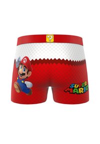 Shorts rouges et blancs avec un graphique de Super Mario sur le côté gauche, le texte "Super Mario" sur la droite, et un point d'interrogation jaune sur la ceinture rouge.