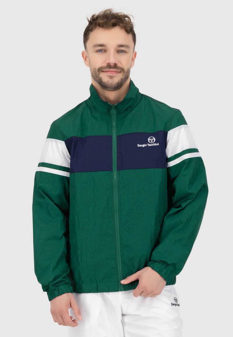 Grüne leichte Jacke mit einem dunkelblauen und weißen horizontalen Streifen auf der Brust. Sie hat einen Stehkragen und einen Reißverschluss sowie einen strukturierten Stoff.