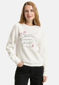 Weißes Sweatshirt mit einem "Apres Ski"-Motiv, das Berge in Schwarz und Rot sowie wellenförmige Linien zeigt. Gerippte Bündchen und Saum.