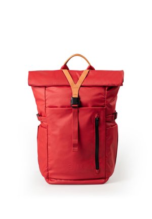 Rode rugzak met oprolbare bovenkant, met bruine leren handgreep, voorste gespband, verticale ritstas en zijklemmen op witte achtergrond.