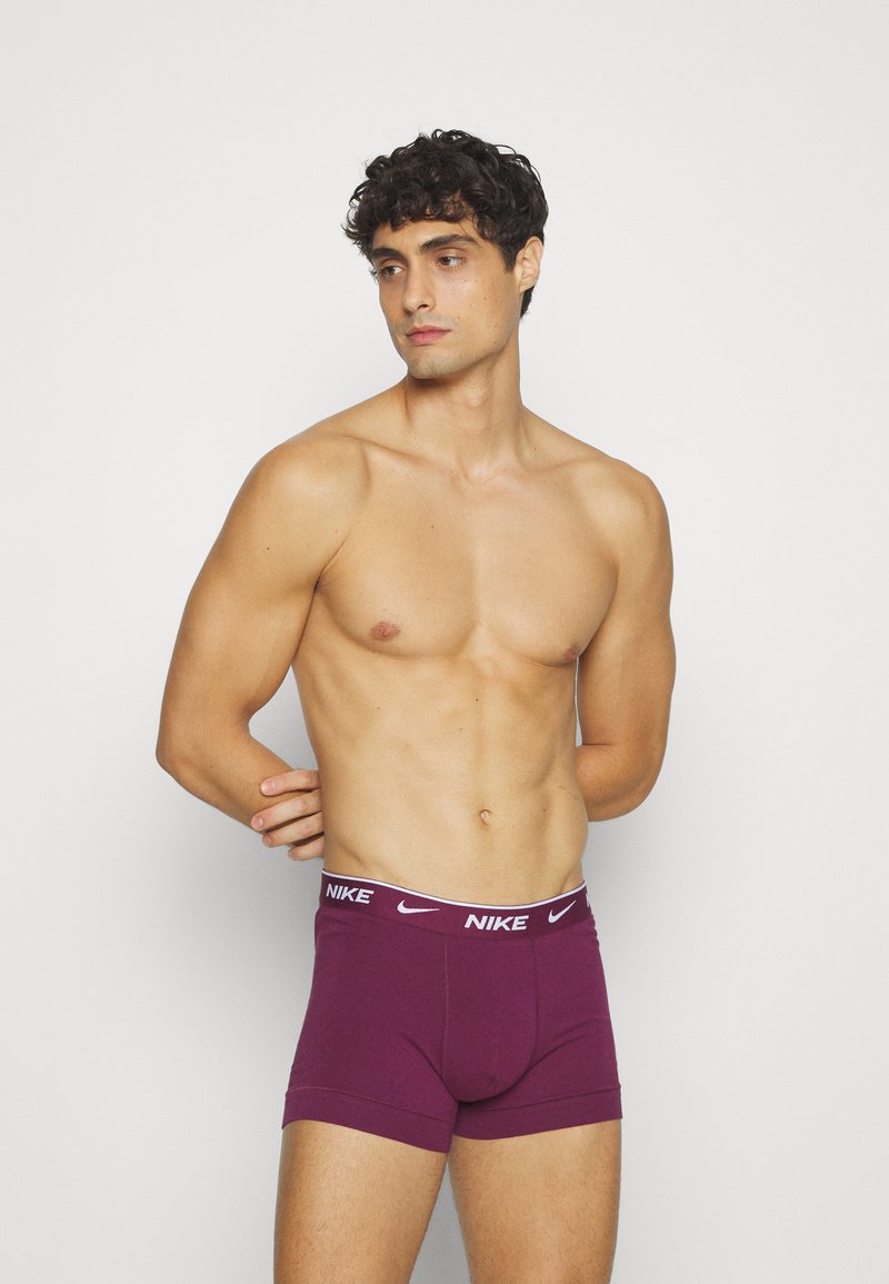 Burgundi színű pamut boxeralsó fehér Nike logós derékkal. Testhez simuló fazon, rövid szárakkal és sima tapintással.