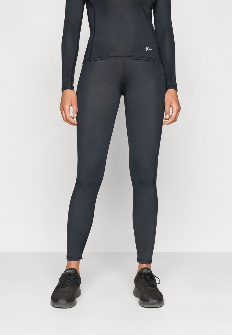 Fekete sportleggings sima, rugalmas anyagból, magas derékkal és látható minták nélkül, fekete sportcipővel párosítva.