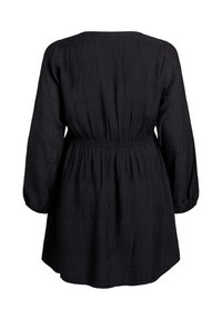 Melna kleita ar gariem piedurknēm un elastīgu vidukļa daļu, izgatavota no strukturētas auduma, ar brīvu piegriezumu, sniedzas līdz vidus augšstilbam.