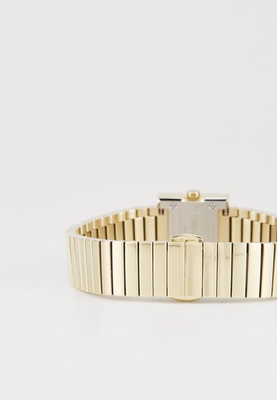 Montre en métal doré avec un bracelet à maillons, de forme rectangulaire, finition polie, dotée d'un fermoir et d'un logo gravé au dos.