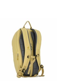 Zaino giallo con un design curvo, imbottitura in rete sulle cinghie e una tasca laterale con zip. Presenta clip nere regolabili e dettagli con logo.