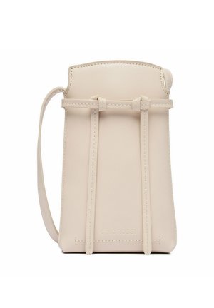 Bolso bandolera pequeño de cuero beige con tirantes delgados y detalles cosidos, diseñado para llevar lo esencial.