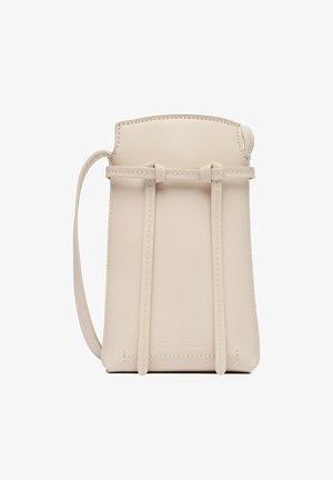 Bolso bandolera pequeño de cuero beige con tirantes delgados y detalles cosidos, diseñado para llevar lo esencial.
